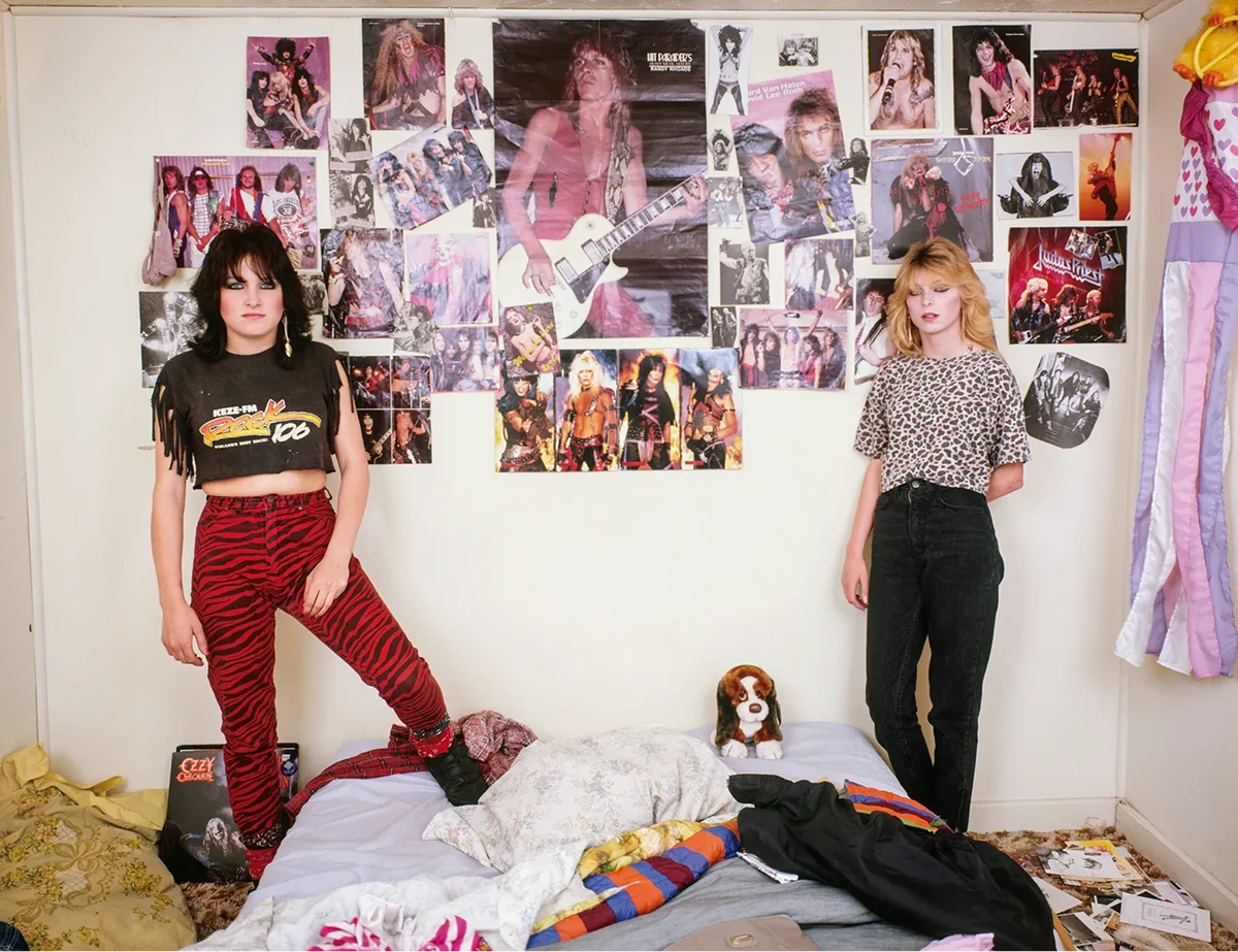 Teenage girls standing in a messy bedroom covered with rock band posters, photographed by Adrienne Salinger in the 1990s.