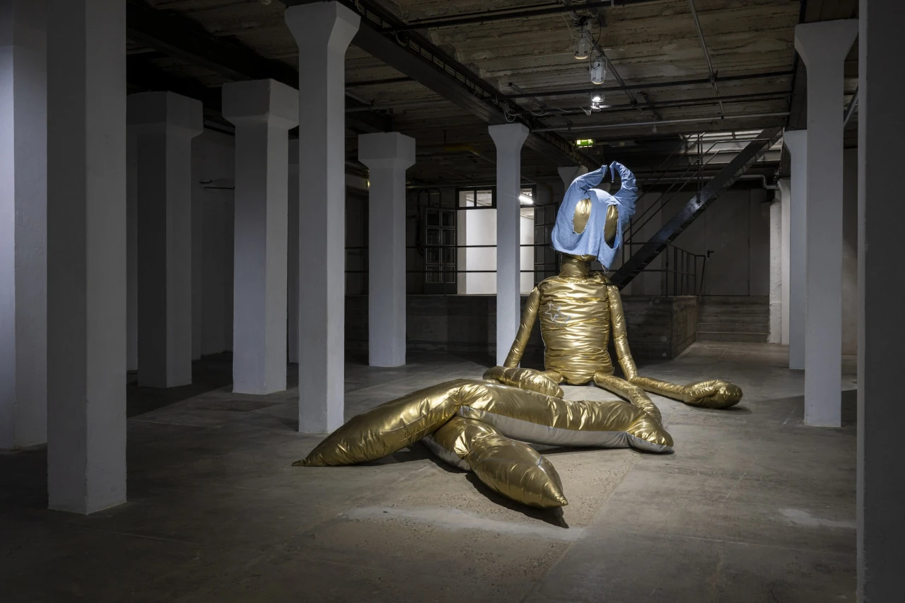 Installation view of Shion (2021) by Thomas Liu Le Lann, a large soft sculpture made of vinyl, cotton and polyester, shown inside an industrial exhibition space.
