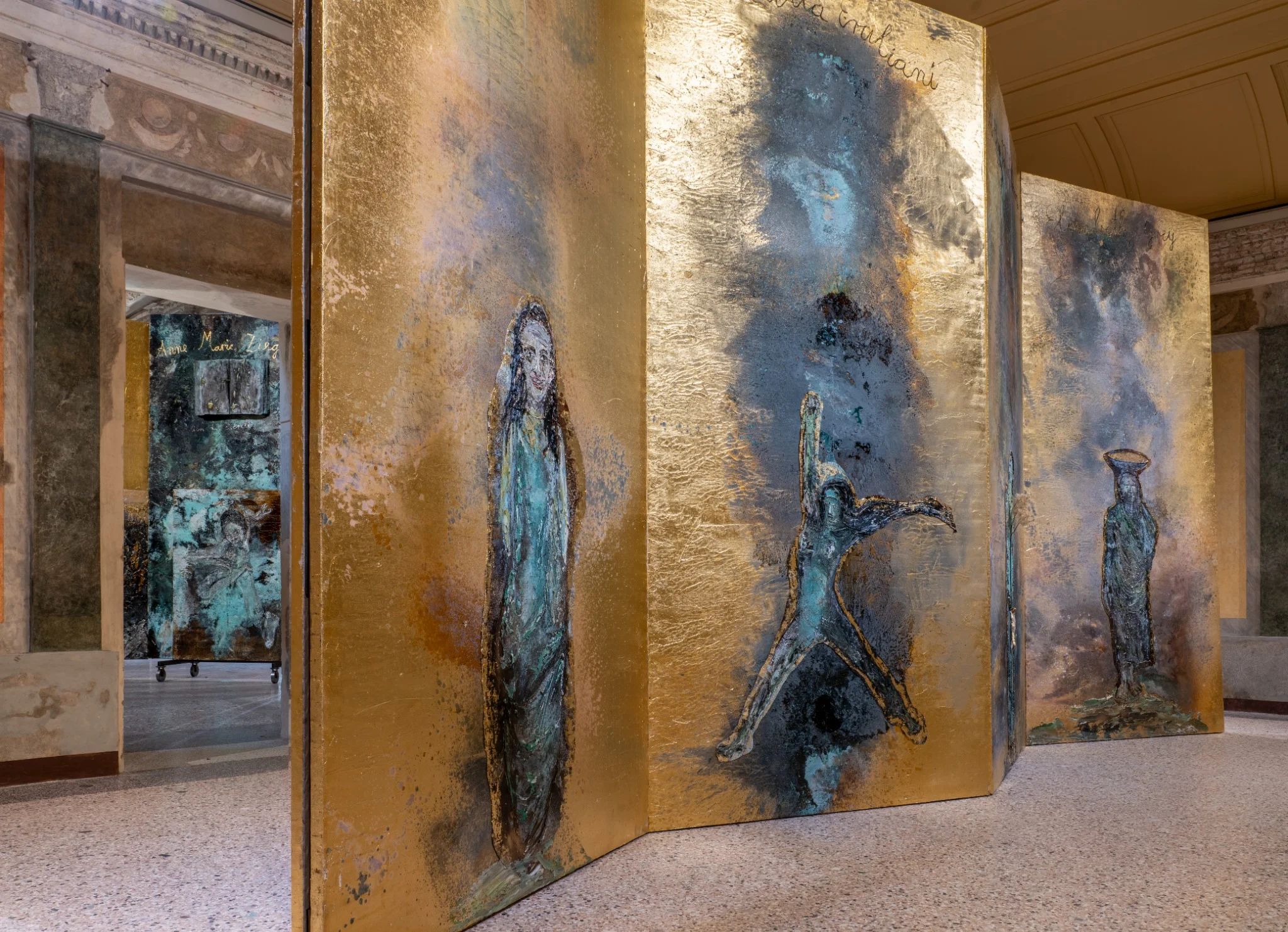 Installation view of Anselm Kiefer’s “The Women Alchemists” at Palazzo Reale, Sala delle Cariatidi, Milan, featuring large-scale textured panels with alchemical and figurative imagery.