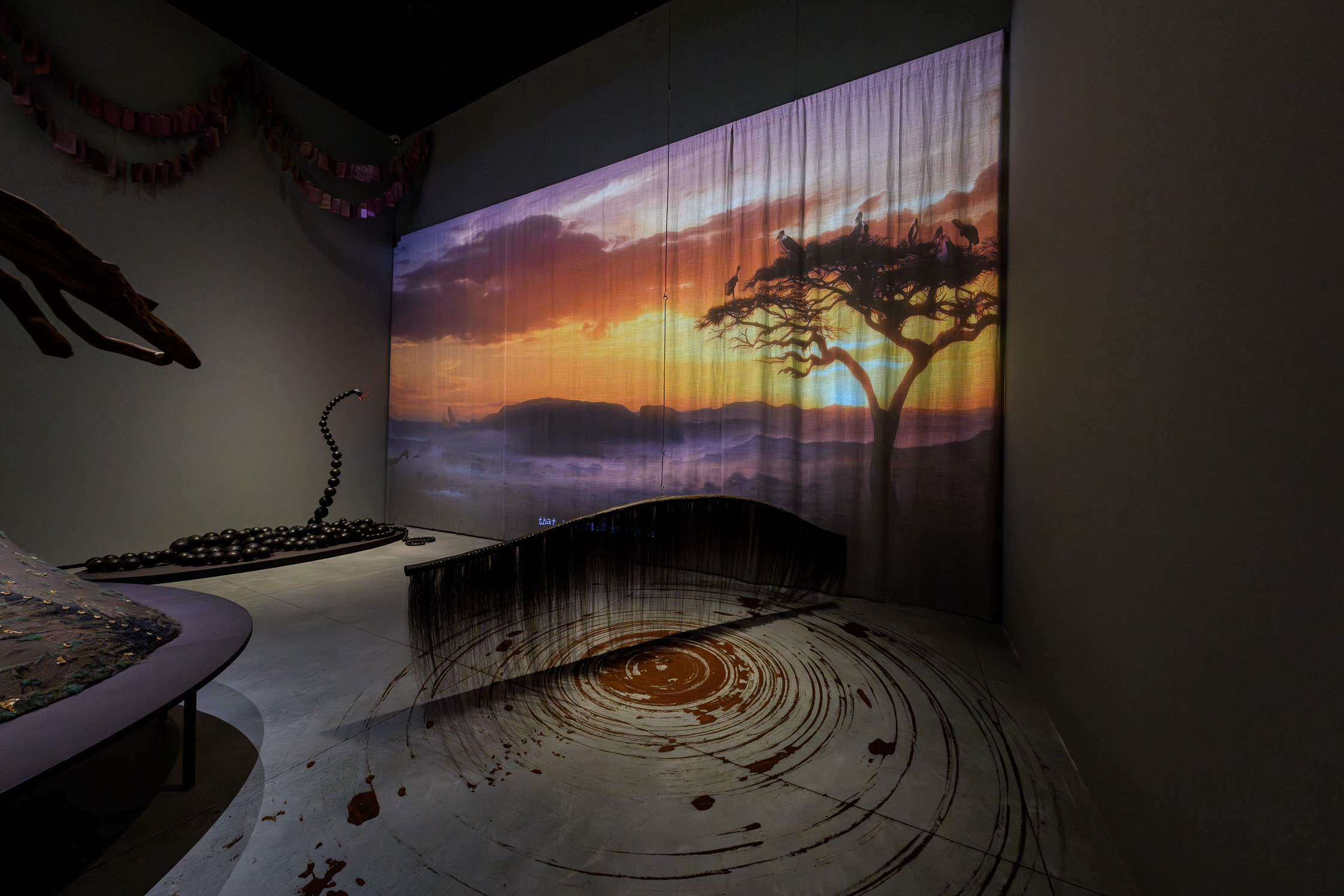 Wangechi Mutu installation at Venice Biennale 2026 featuring African sunset projection, sculptural elements, and floor markings