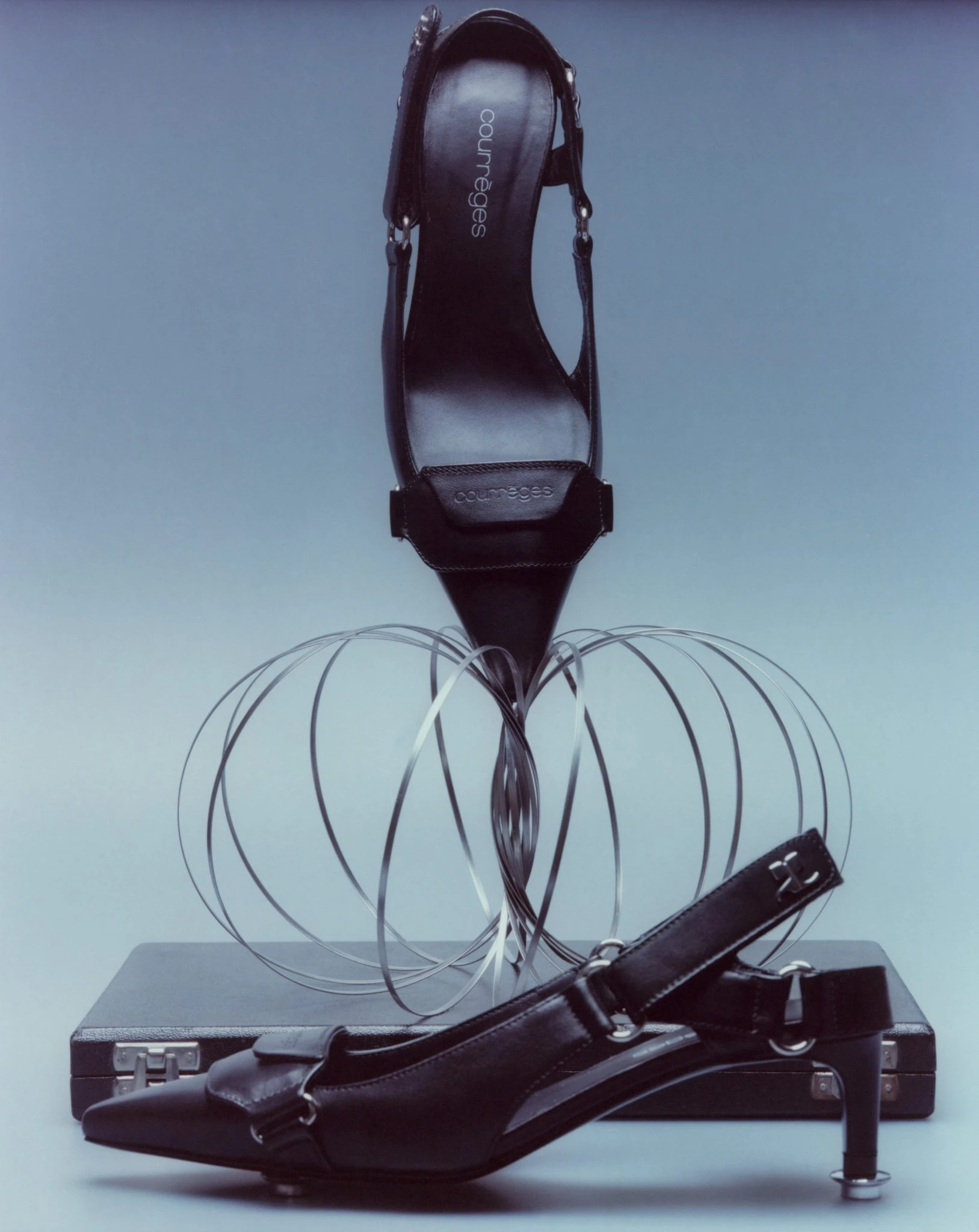 Courrges black leather slingback heels styled with a wire sculpture and briefcase, photographed by Balazs Fromm
