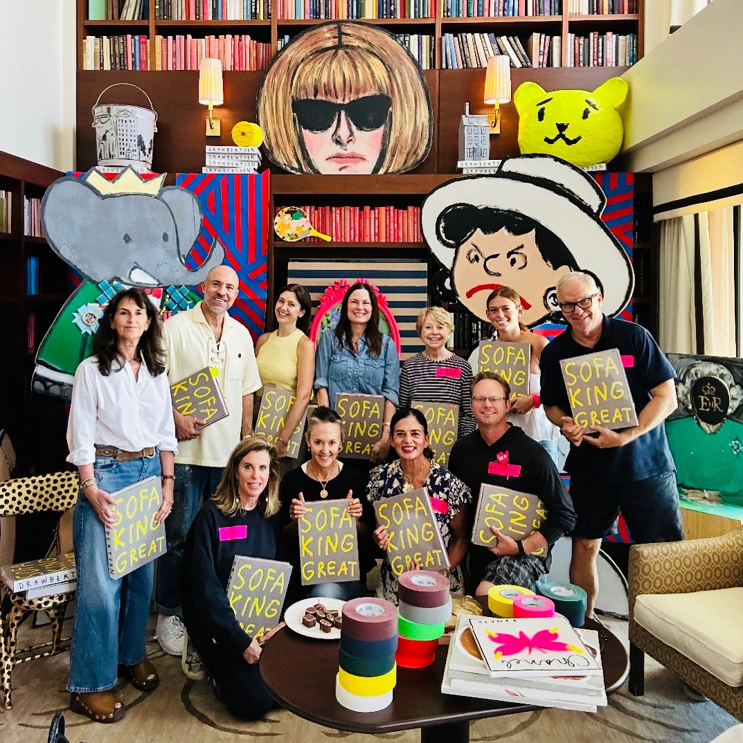 Donald Robertson and group holding Sofa King Great books surrounded by colorful pop art illustrations