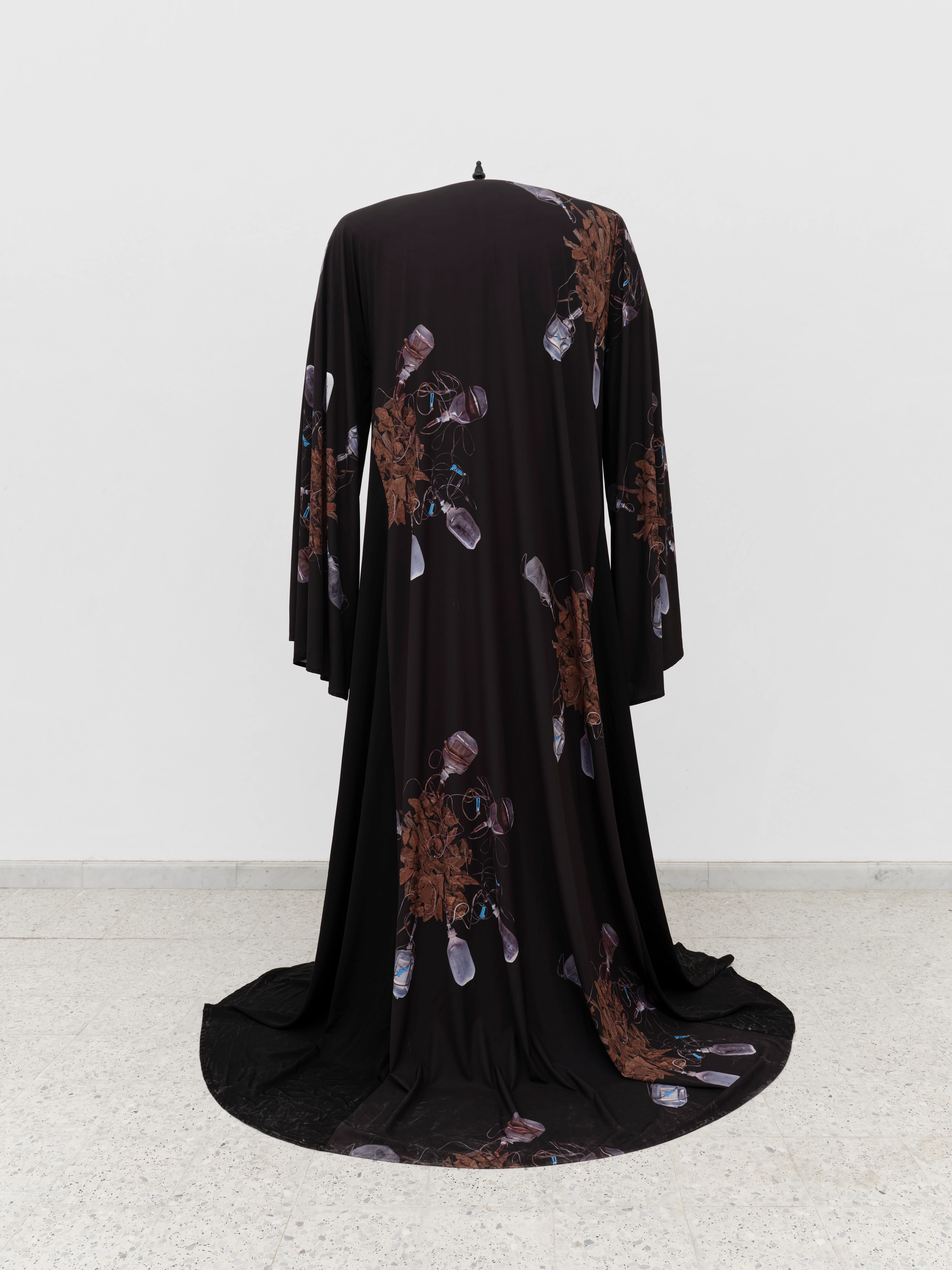 Oud Abaya black floor-length robe with trailing hem and botanical crystal print, displayed on stand