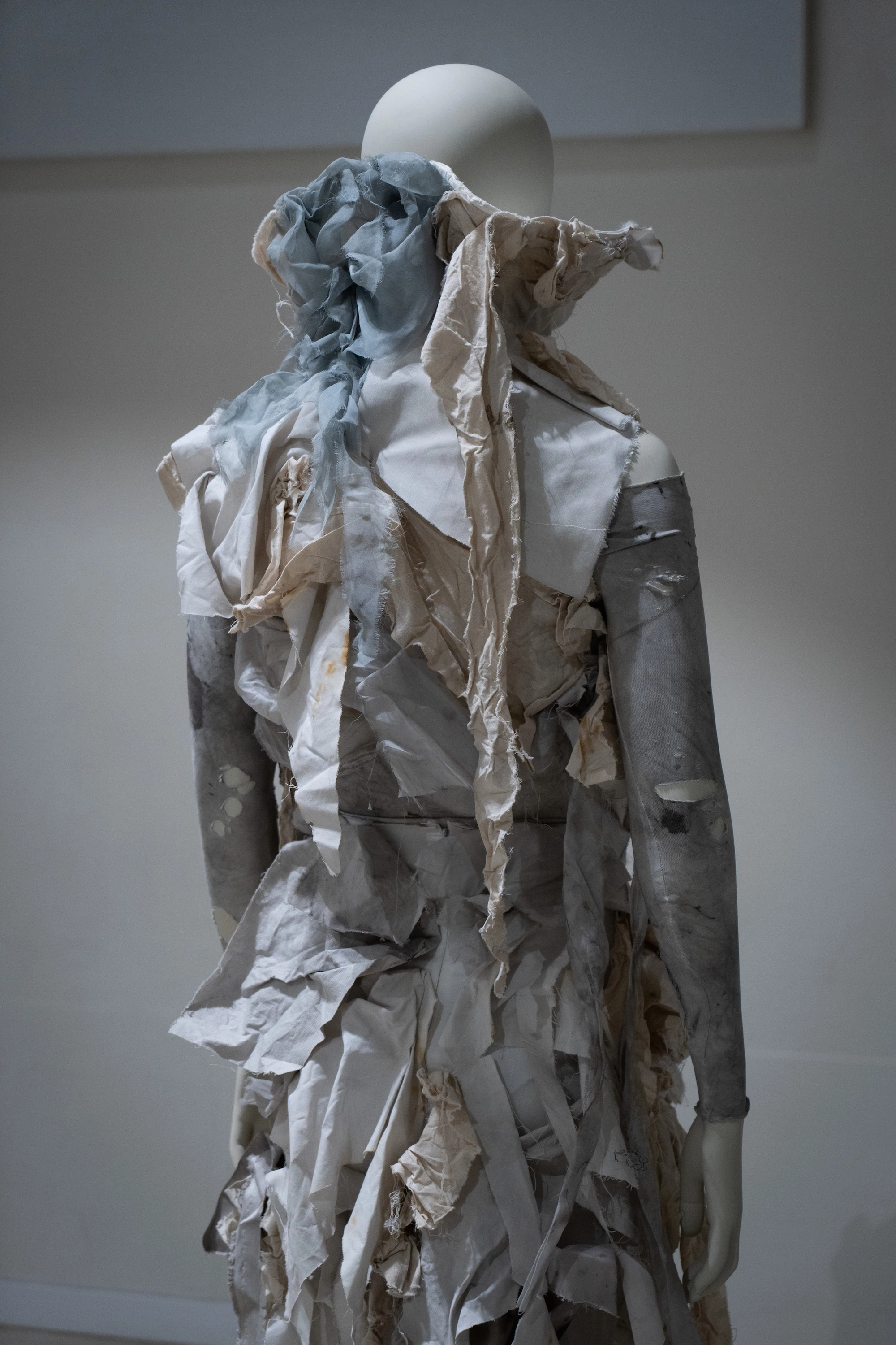 Sculptural avant-garde garment of layered torn fabric on mannequin, Cecilia Turrini, UNFOLD exhibition IED Milan 2026