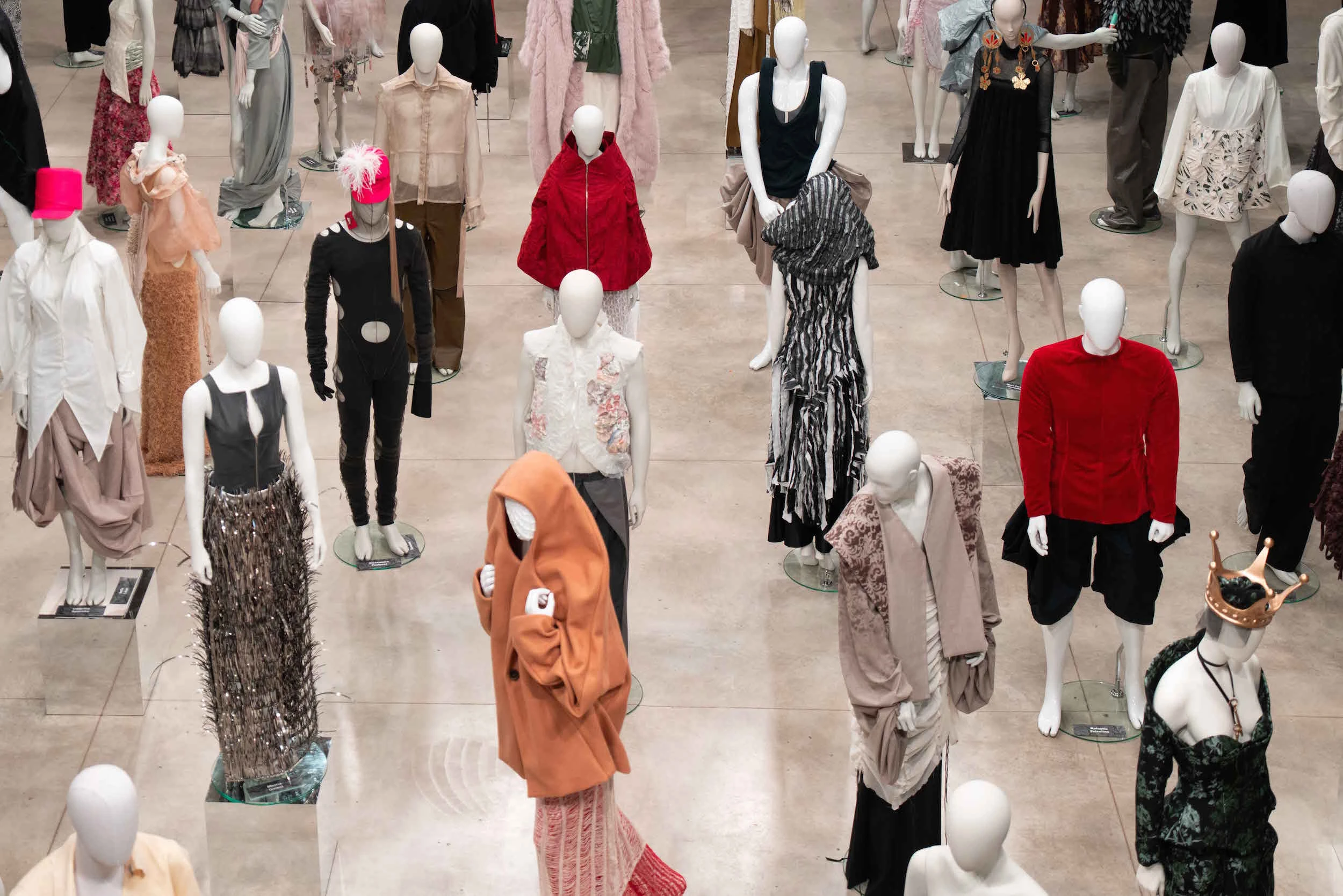 UNFOLD exhibition installation view with diverse mannequins in avant-garde fashion, IED Milan 2026 end-of-year show