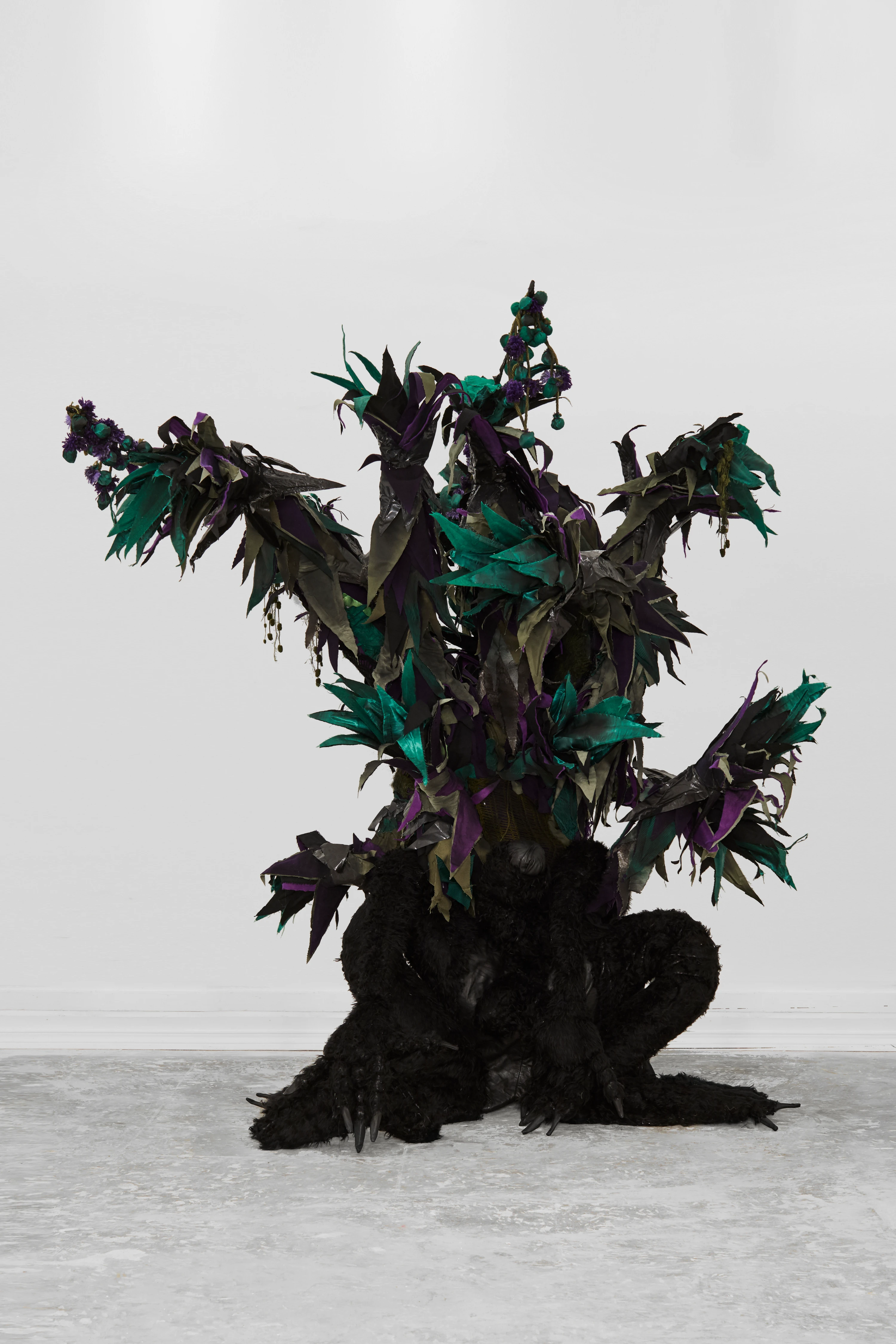 Paloma Contreras Lomas sculptural figure with black fur body and dark teal purple botanical foliage in gallery