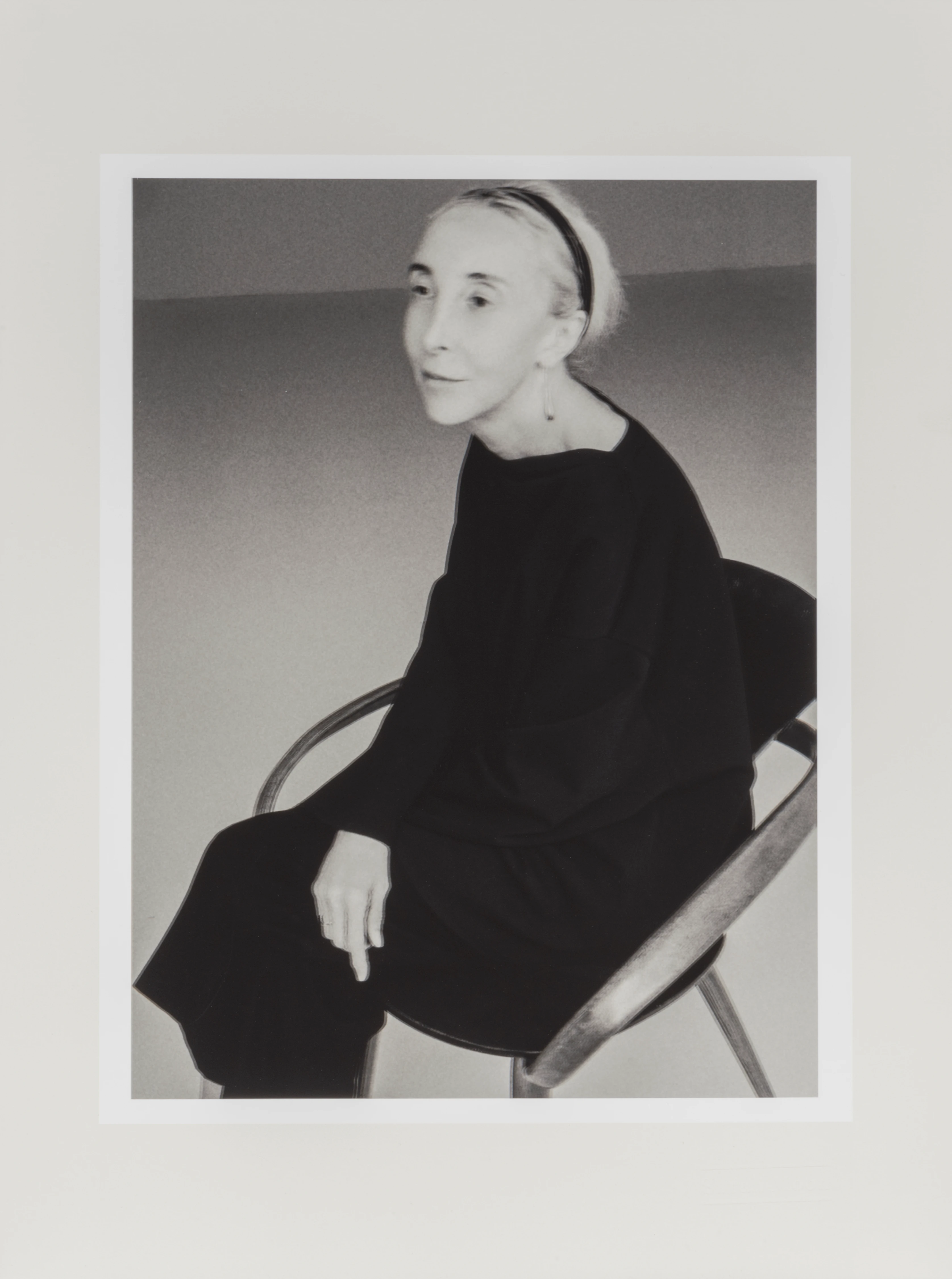 Sarah Moon black-and-white portrait of Carla Sozzani seated on metal chair, 2018