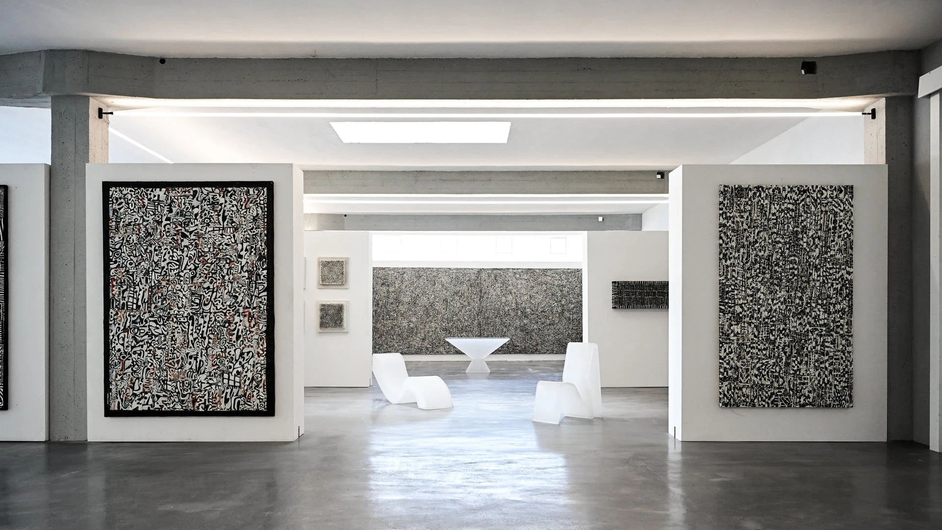 Fondazione Sozzani gallery interior, Milan, featuring large-scale black-and-white text paintings and white sculptural furniture