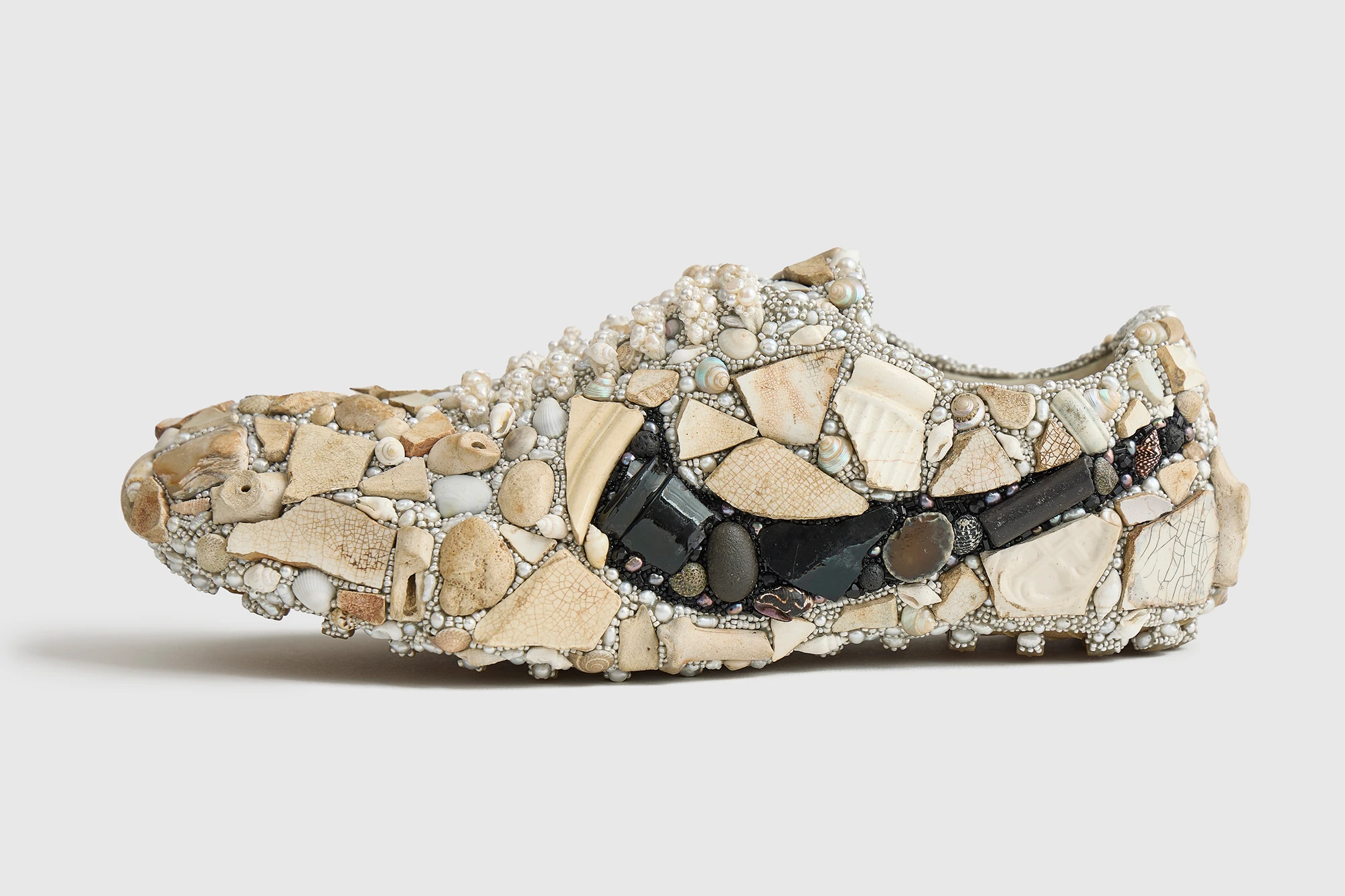 Emily Frances Barrett x Nike sneaker encrusted with shells, pearls, pebbles, and ceramic fragments in mosaic art form