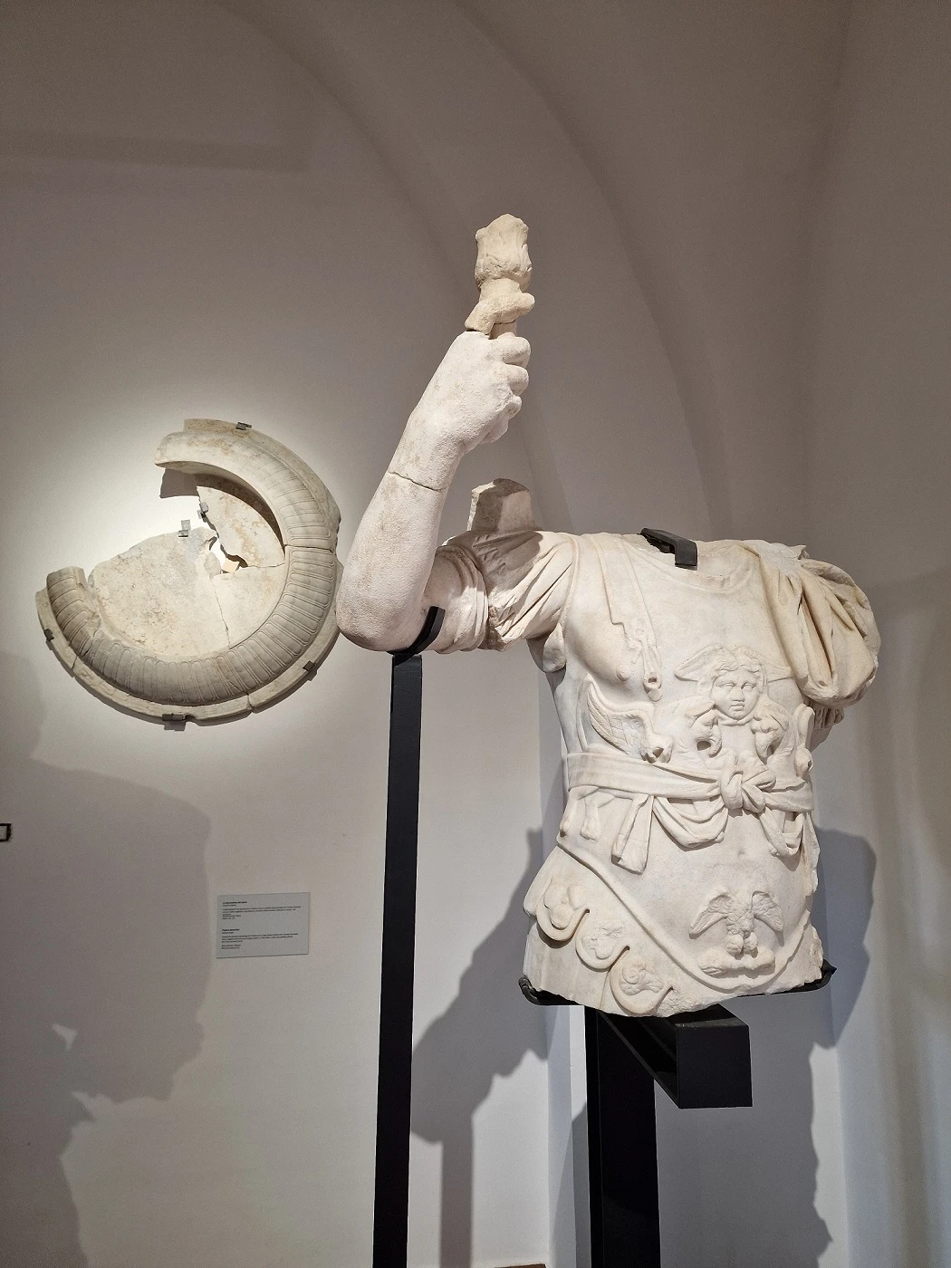 Marble torso of Emperor Trajan with raised arm and clypeus, sculptural fragments from Roman theater of Sessa Aurunca