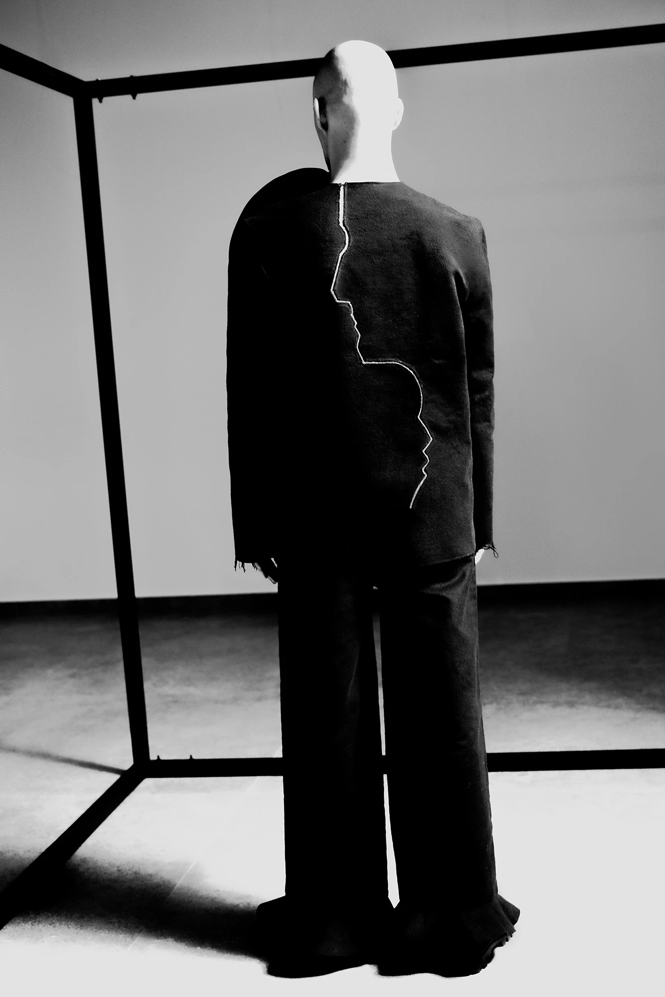 DZHUS ABSOLUTE collection dark suit with white face silhouette seam detail on mannequin, rear view