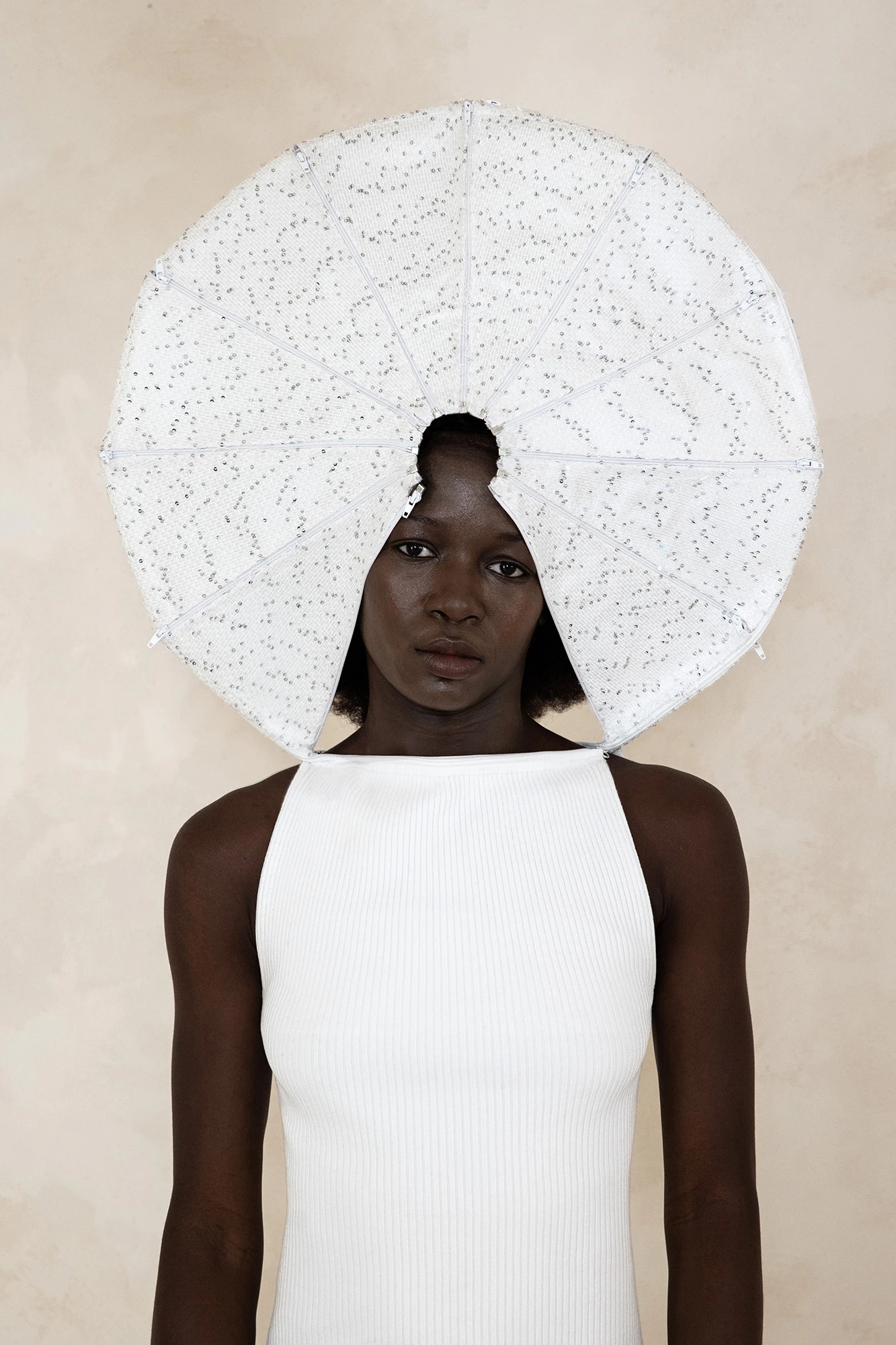 DZHUS ANTICON collection model wearing white ribbed top and sculptural circular headpiece, shot at CONCEPT 11 Warsaw