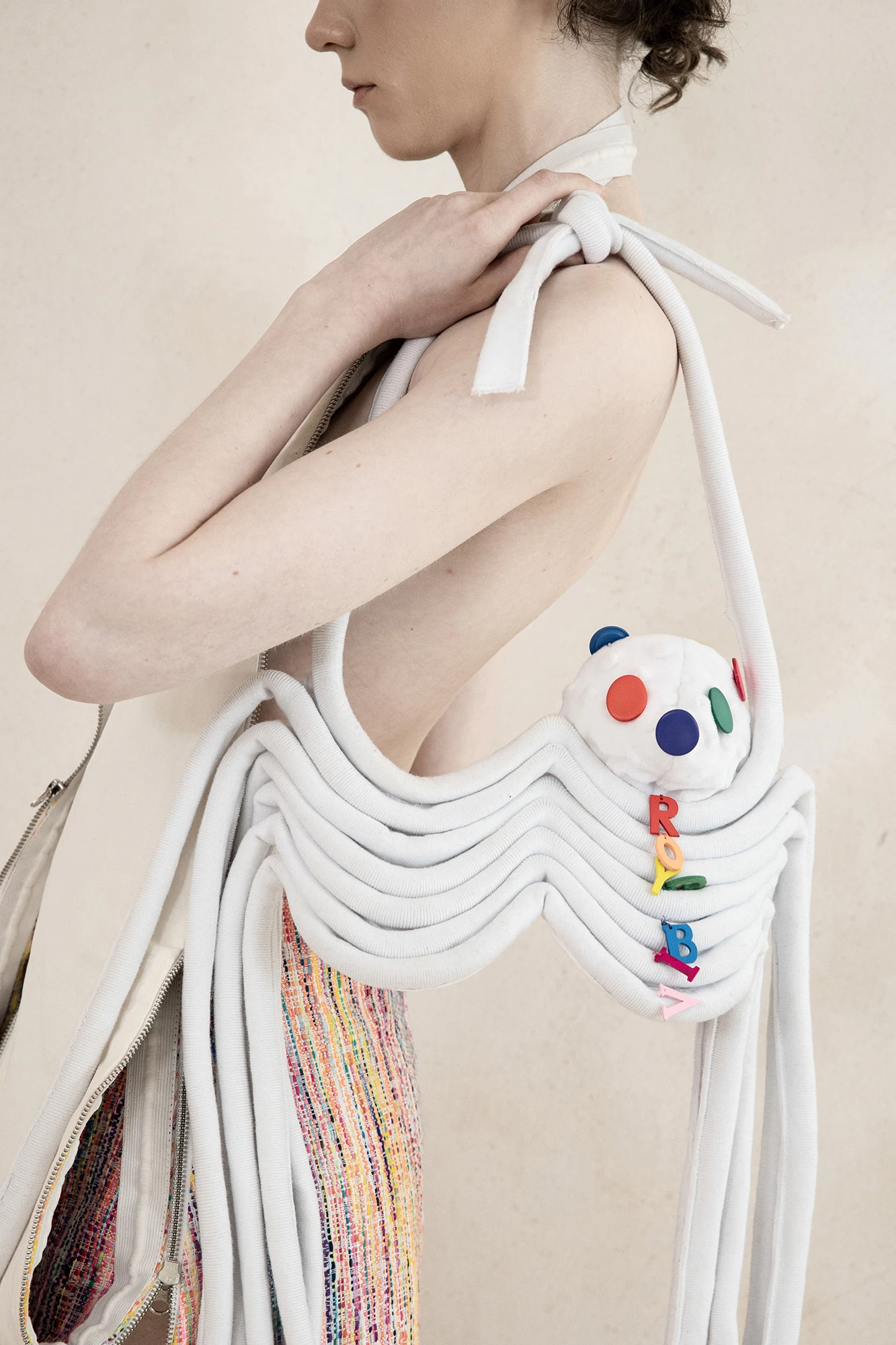 DZHUS ANTICON collection white rope sculptural bag with colorful clay accents worn as body harness