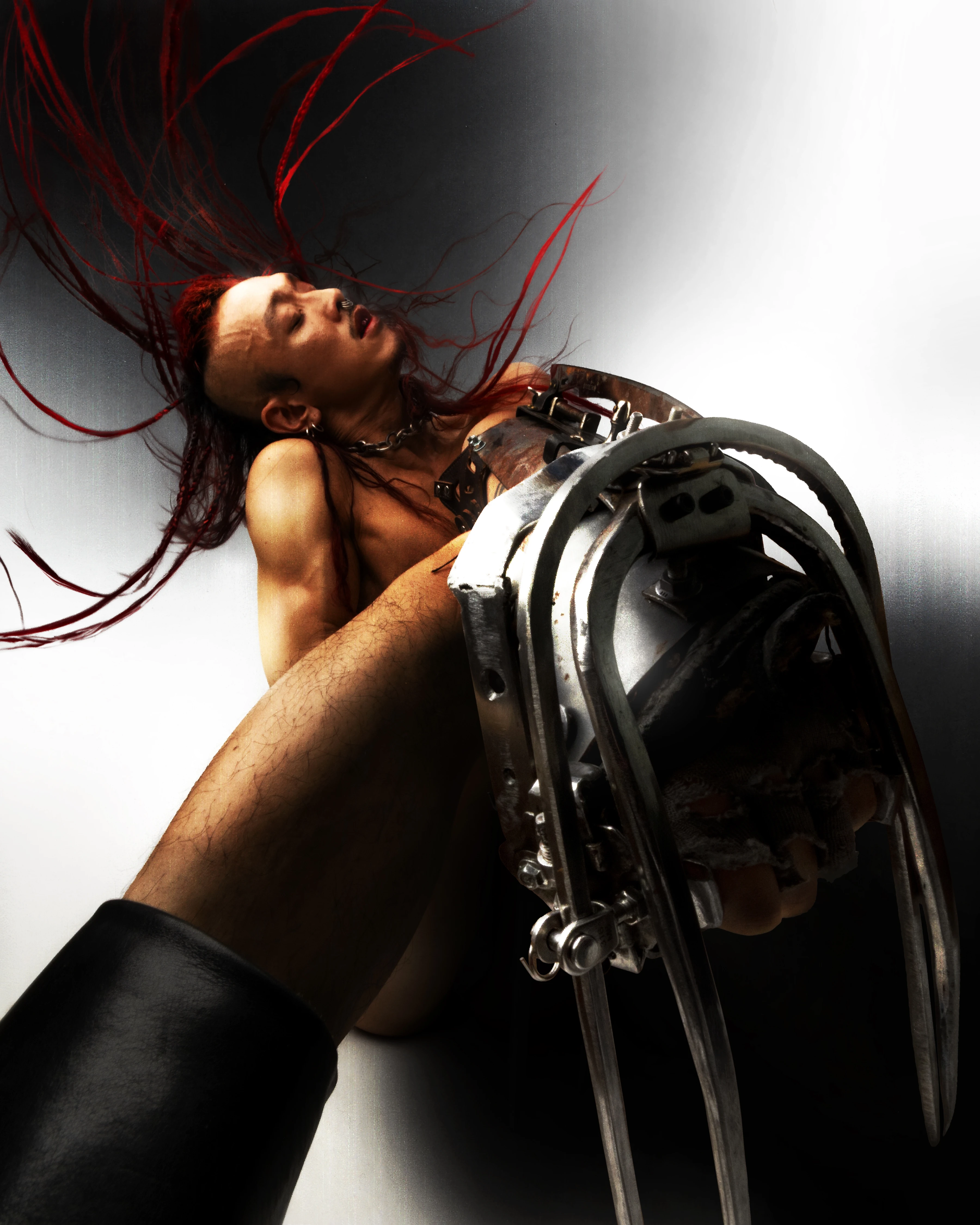 Editorial fashion portrait by James Vu Anh Pham featuring red-haired model with mechanical claw prop, dramatic motion blur