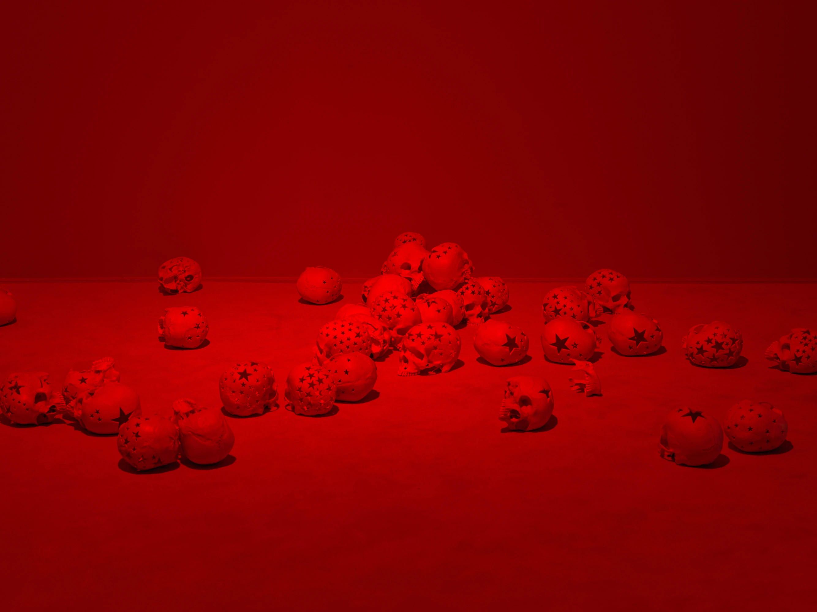 Douglas Gordon's Happy Birthday to Me, 2008—ceramic skull-like spheres with star perforations bathed in red light