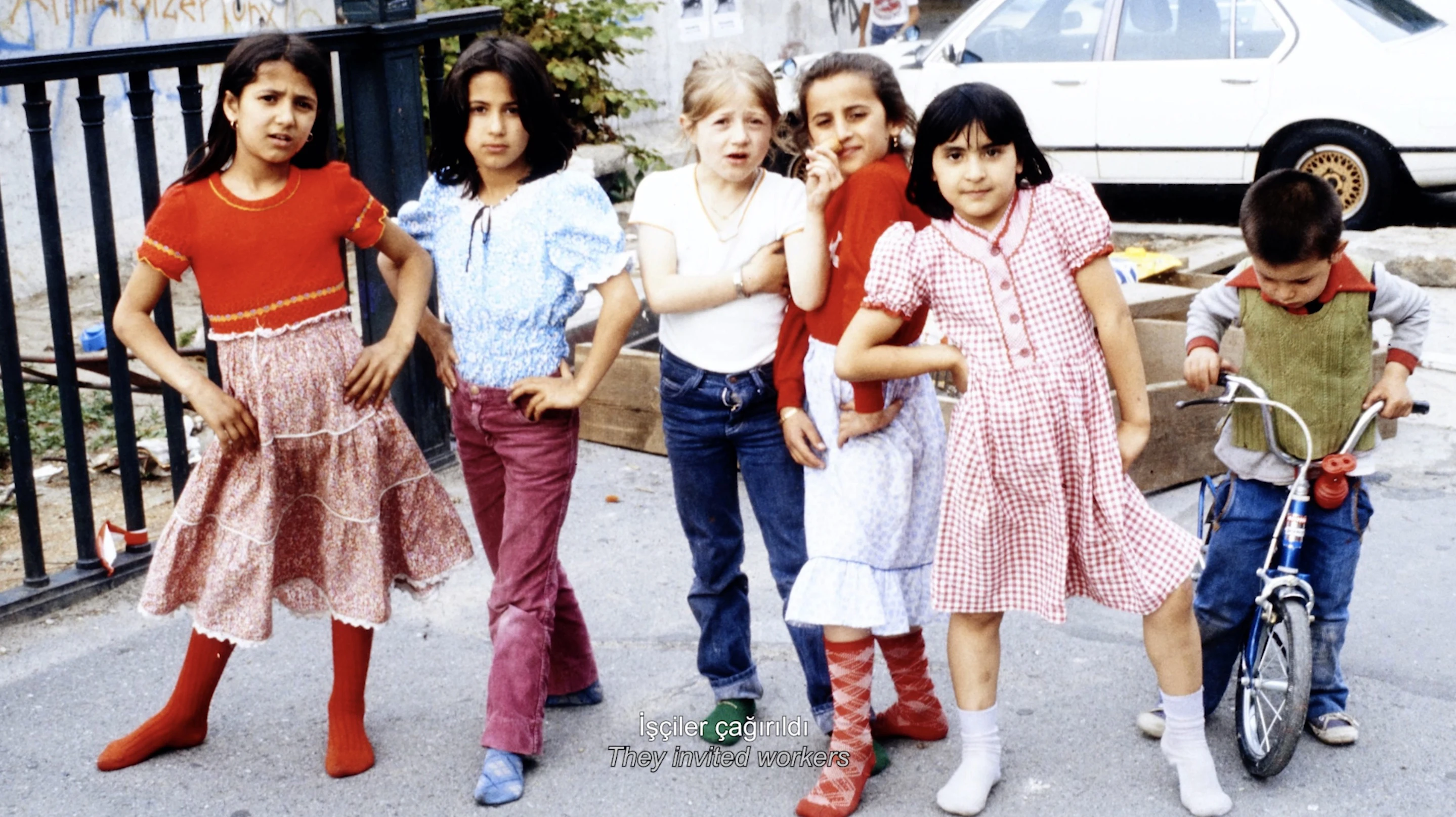 Film still from Pnar renci's Gurbet is a home now, 2021, showing children posing on a street