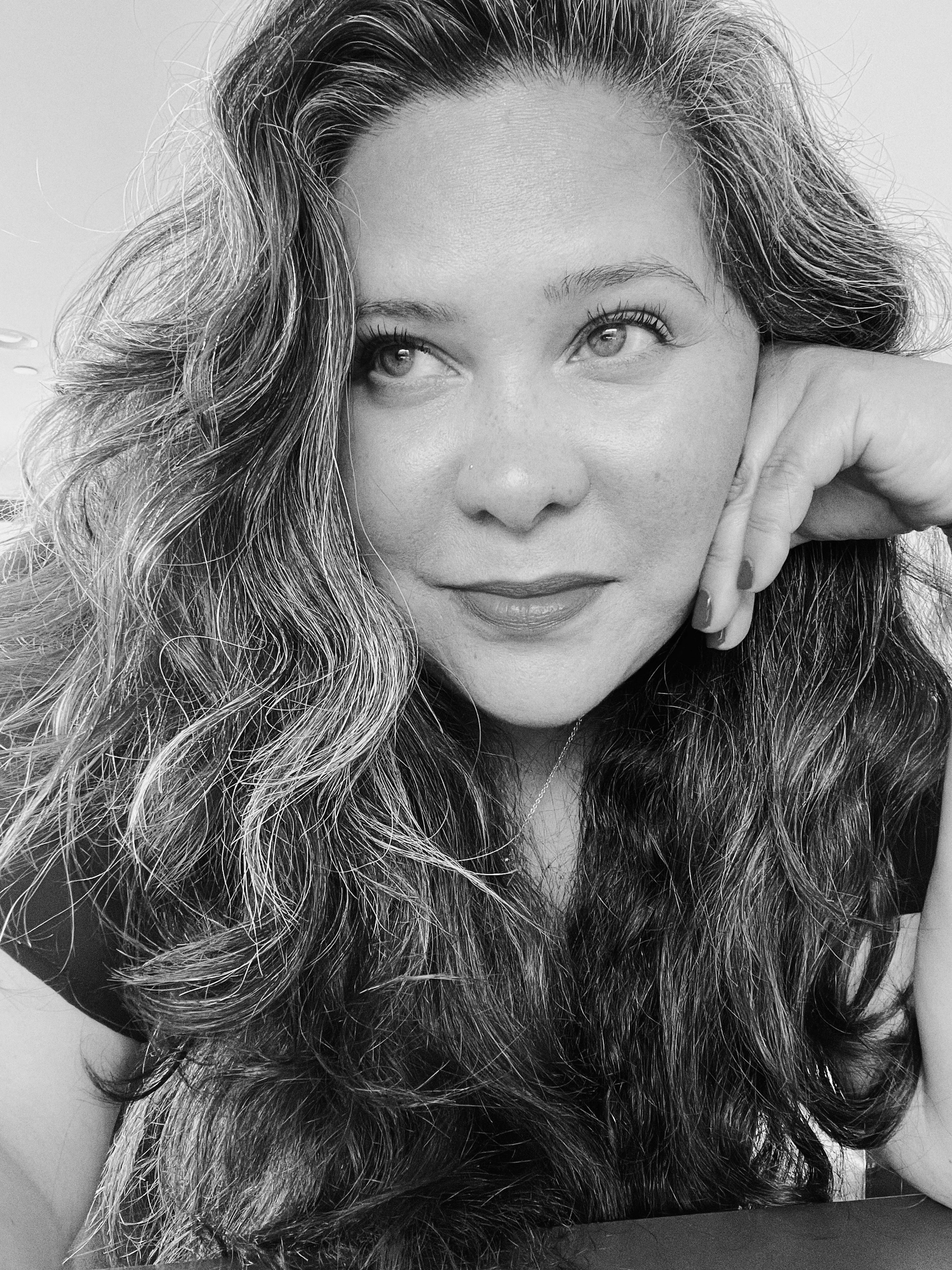 Ana Carolina Letelier, Pura Buena Onda founder, with long wavy hair resting her chin on her hand