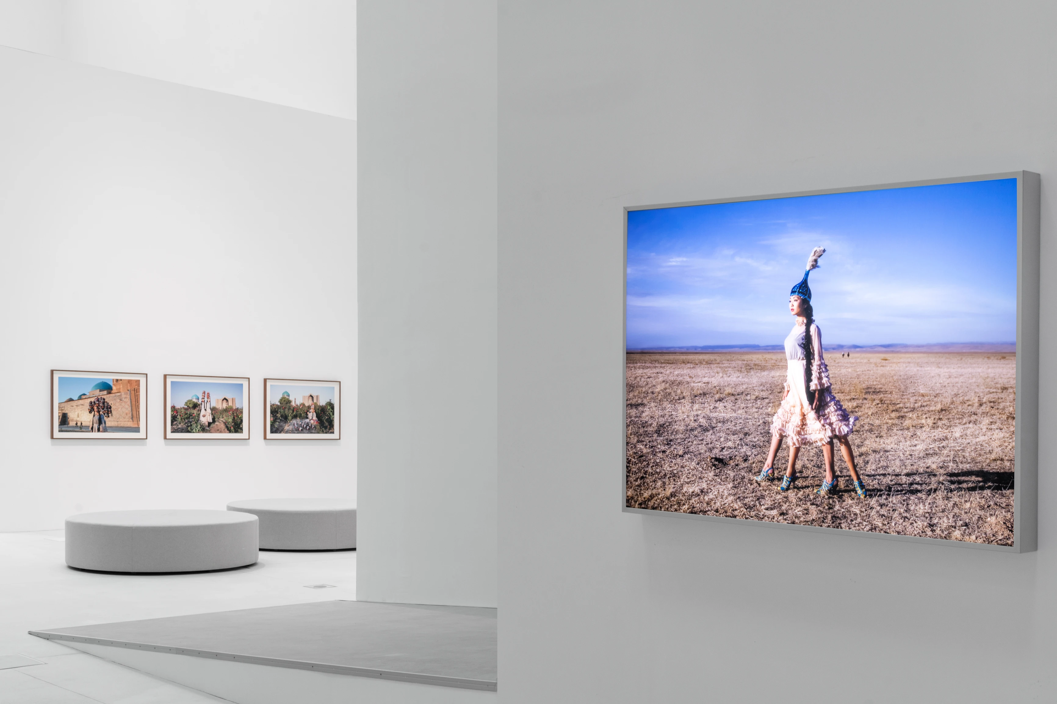 Almaty Museum of Arts gallery with large desert fashion photograph and three smaller framed works on white walls