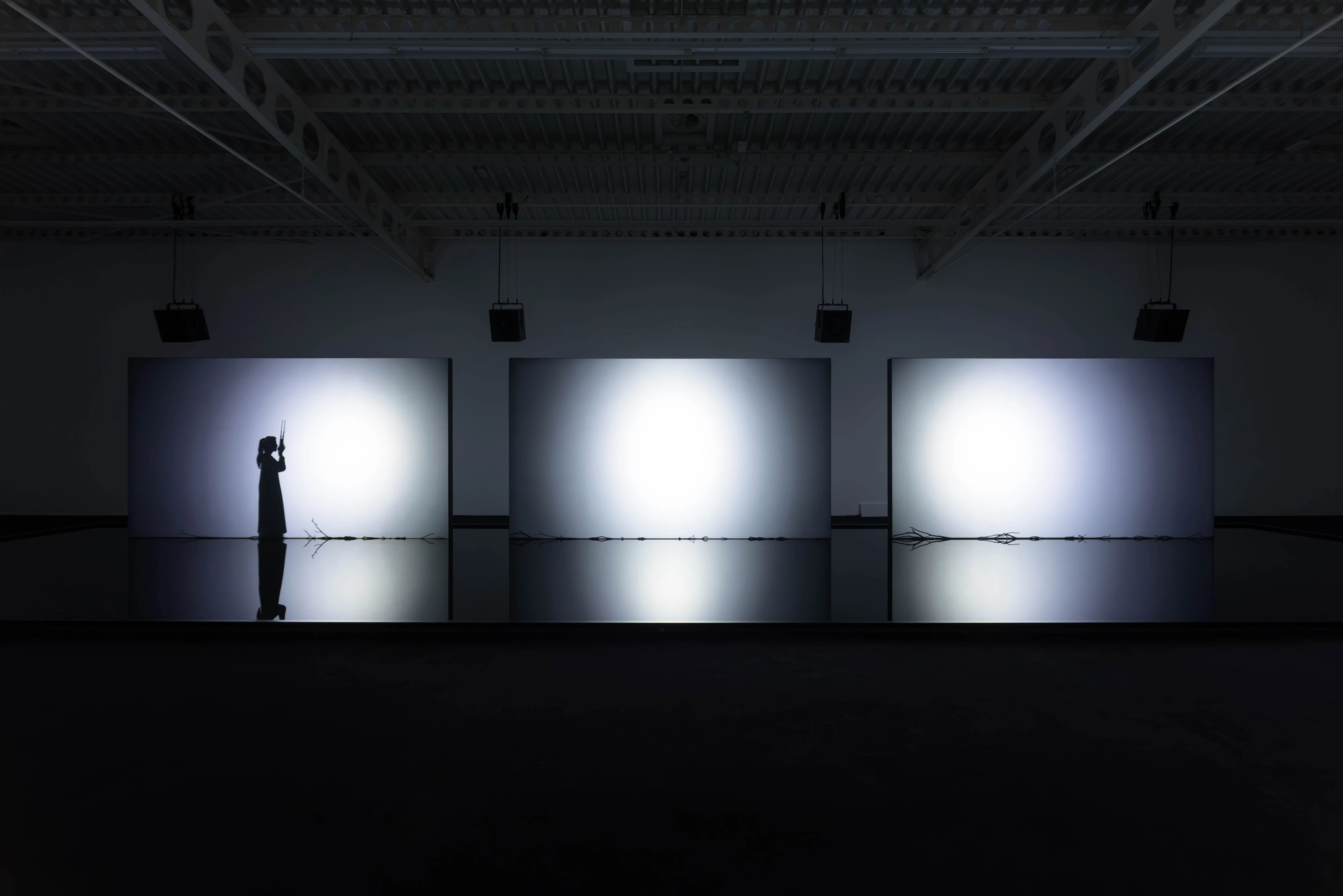 Silhouette before glowing triptych screens with barbed wire, Ryuichi Sakamoto and Shiro Takatani's TIME TIME at Hamburger Bahnhof