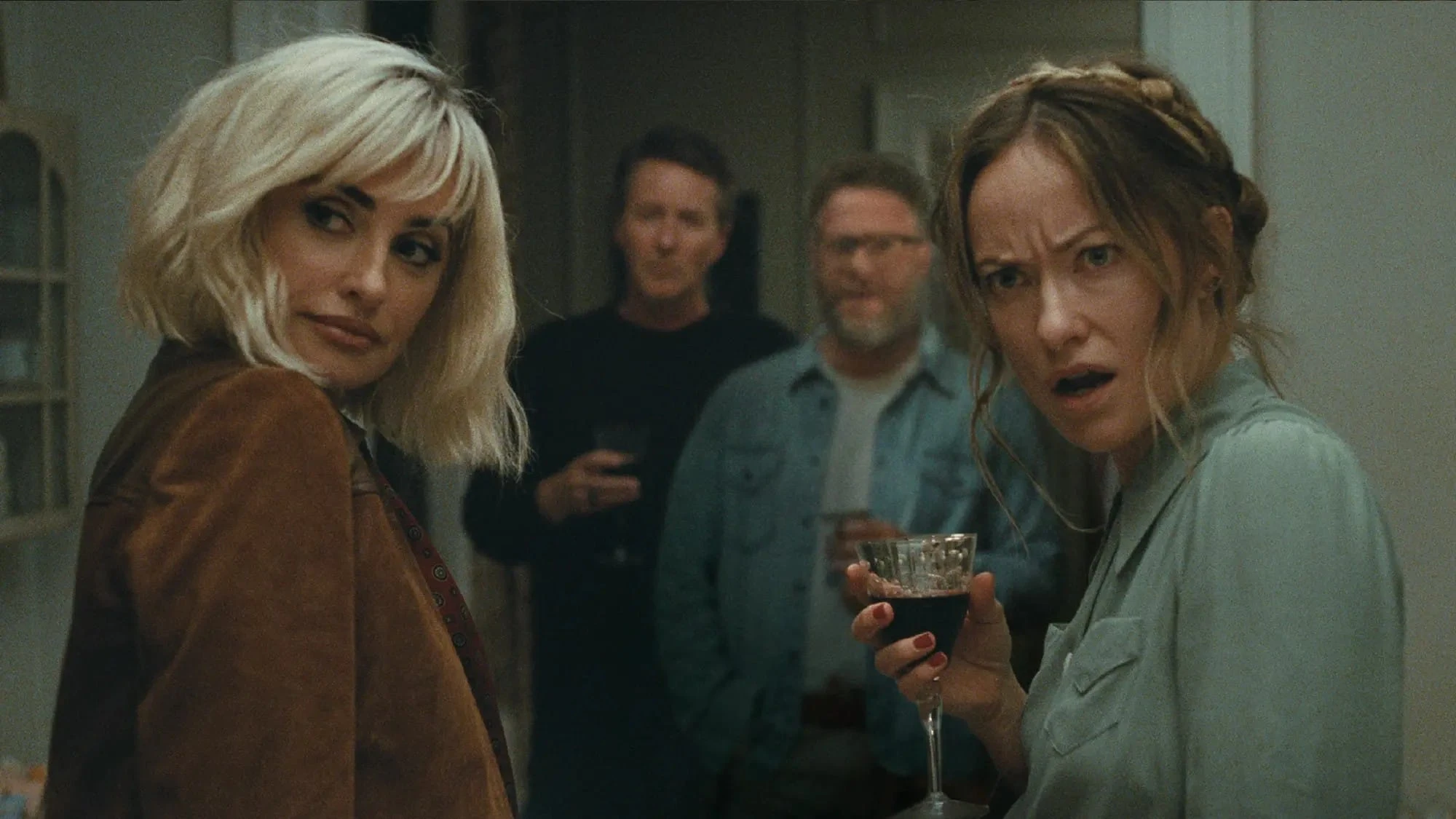 Olivia Wilde and Penelope Cruz at a party with Seth Rogen and Edward Norton in A24's The Invite