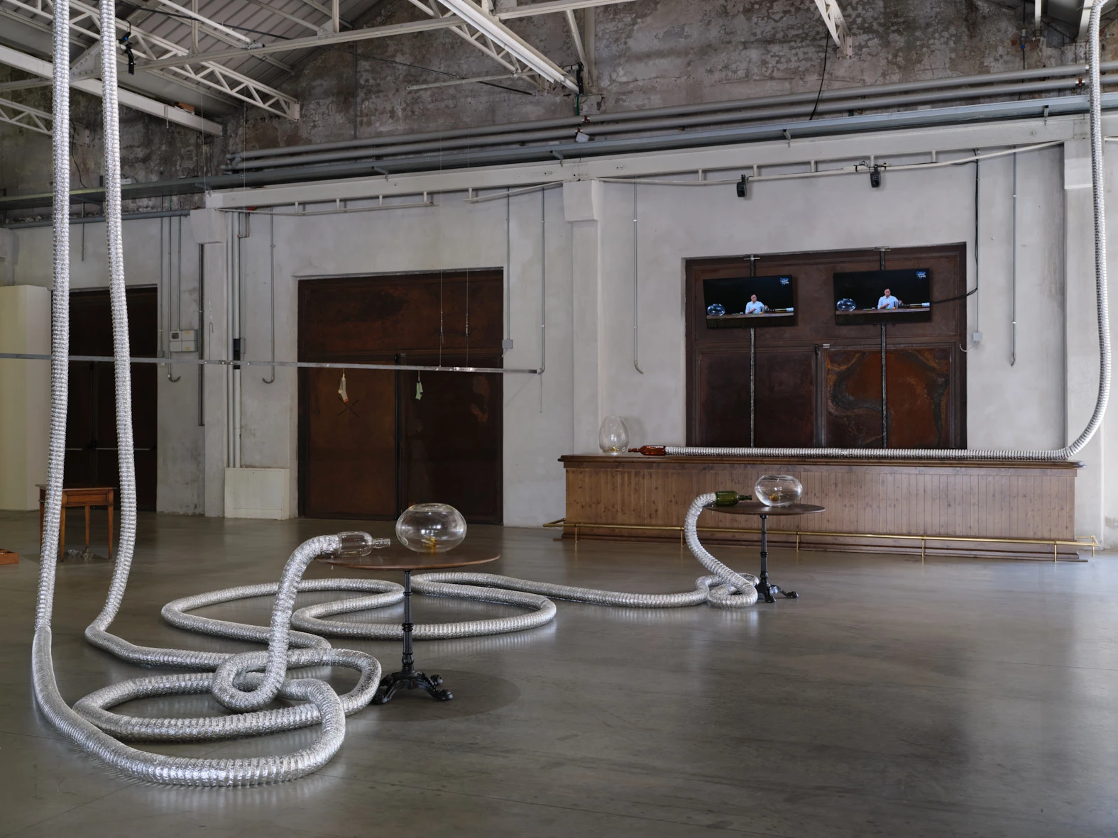Aki Sasamoto XYZ installation view with coiled silver ducts and glass vessels at Pirelli HangarBicocca Milan