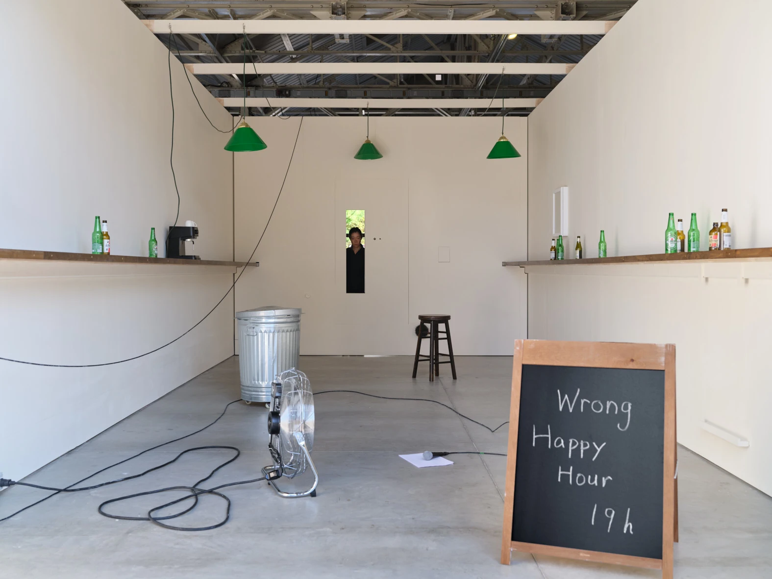 Aki Sasamoto Wrong Happy Hour installation view with bar shelves, green pendant lights, and chalkboard sign at Pirelli HangarBicocca Milan
