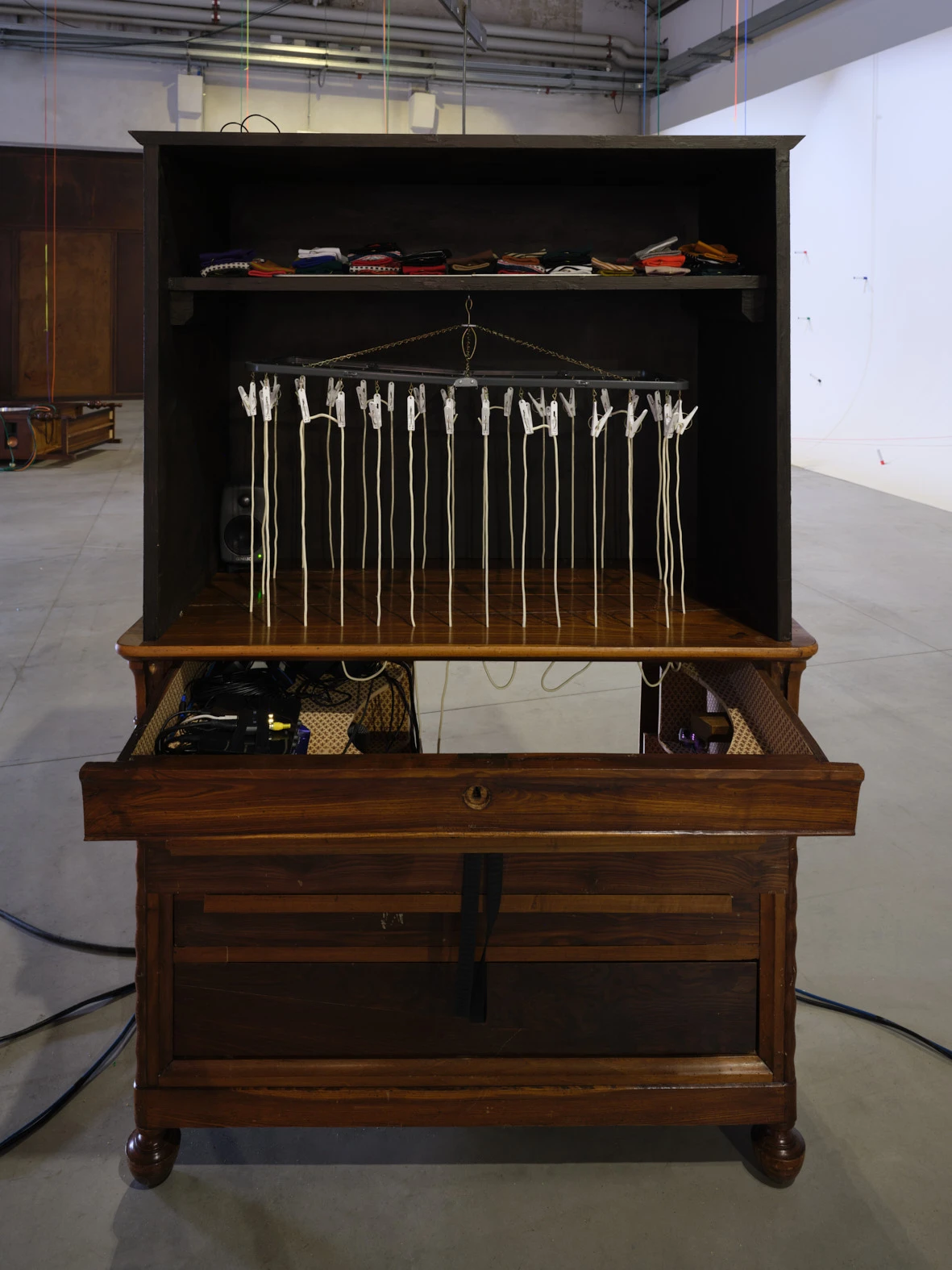 Aki Sasamoto 'Secrets of My Mother's Child' installation detail, antique cabinet with hanging white cords, Pirelli HangarBicocca 2026