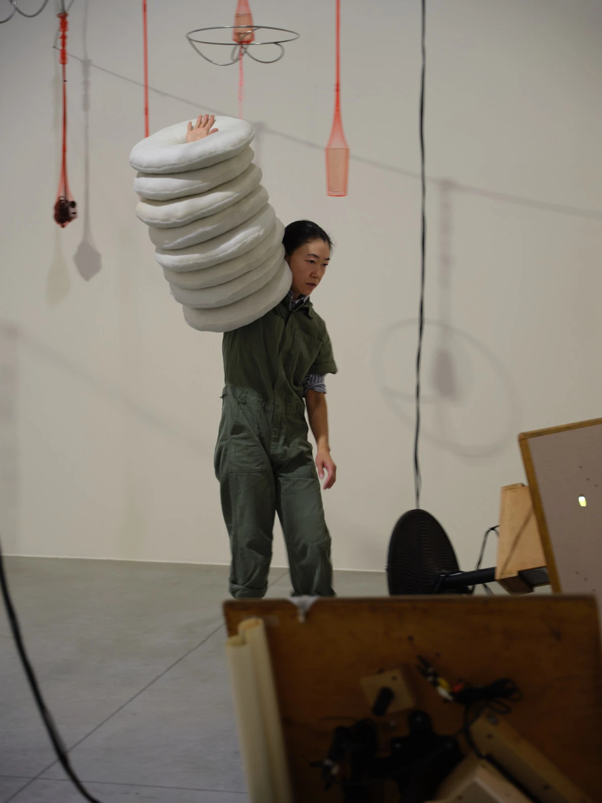 Aki Sasamoto balancing stacked white rings in Strange Attractors performance, Pirelli HangarBicocca Milan