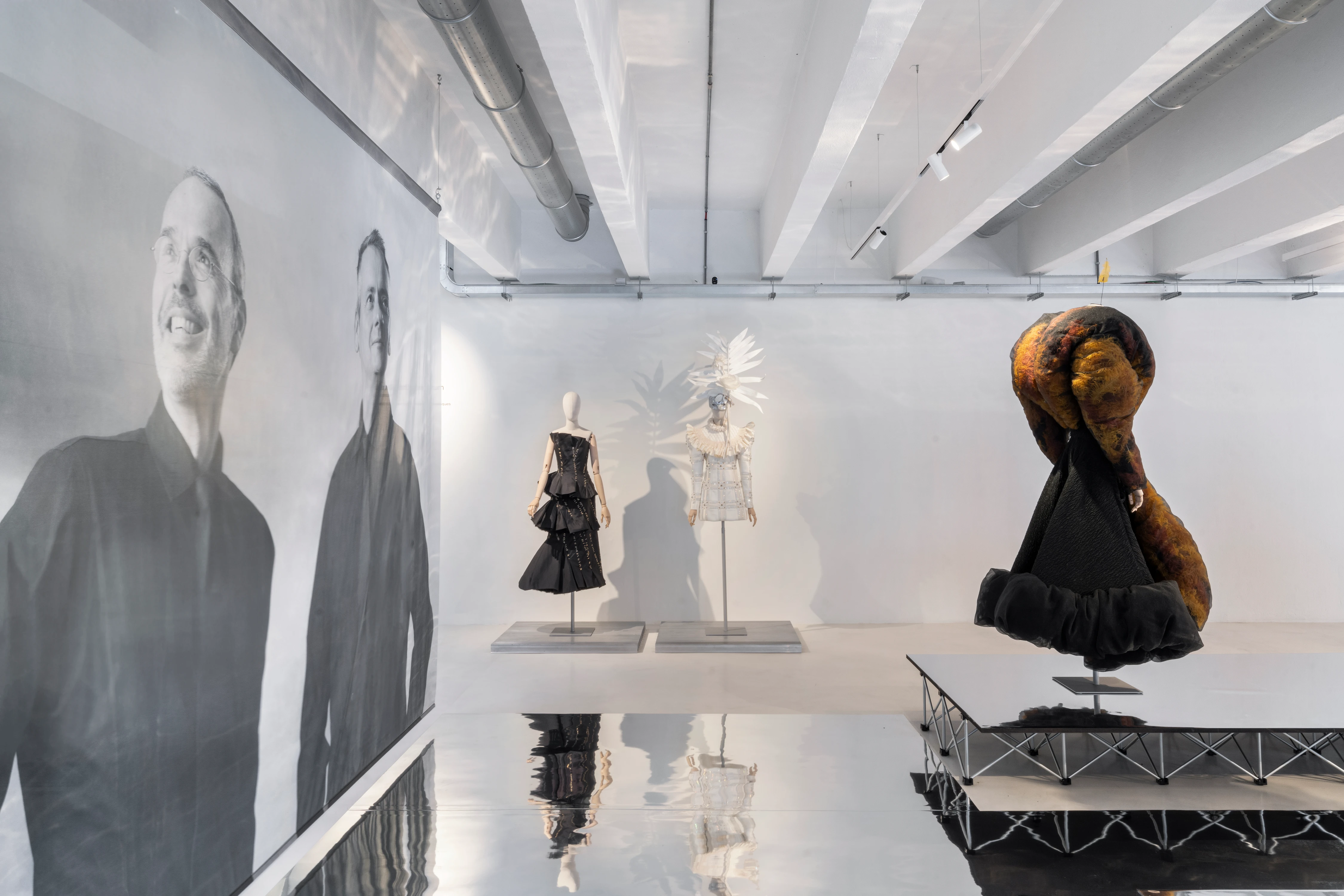 Viktor&Rolf Spectrum installation view at 10 Corso Como Milan, featuring sculptural fashion pieces on mannequins with large-scale portrait backdrop
