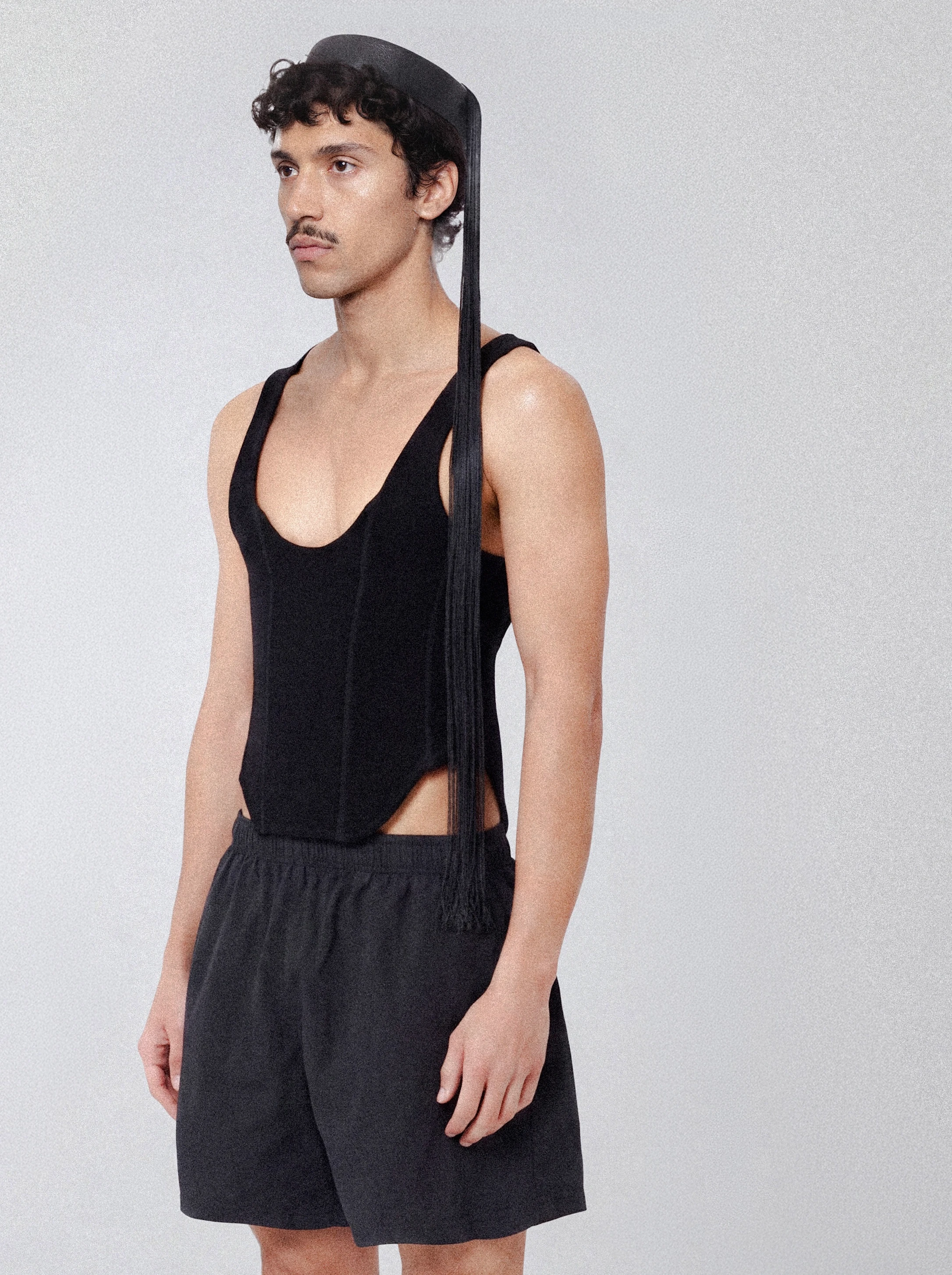 Goksenin Ay wearing black tank bodysuit and shorts from debut collection Lament, minimalist fashion editorial
