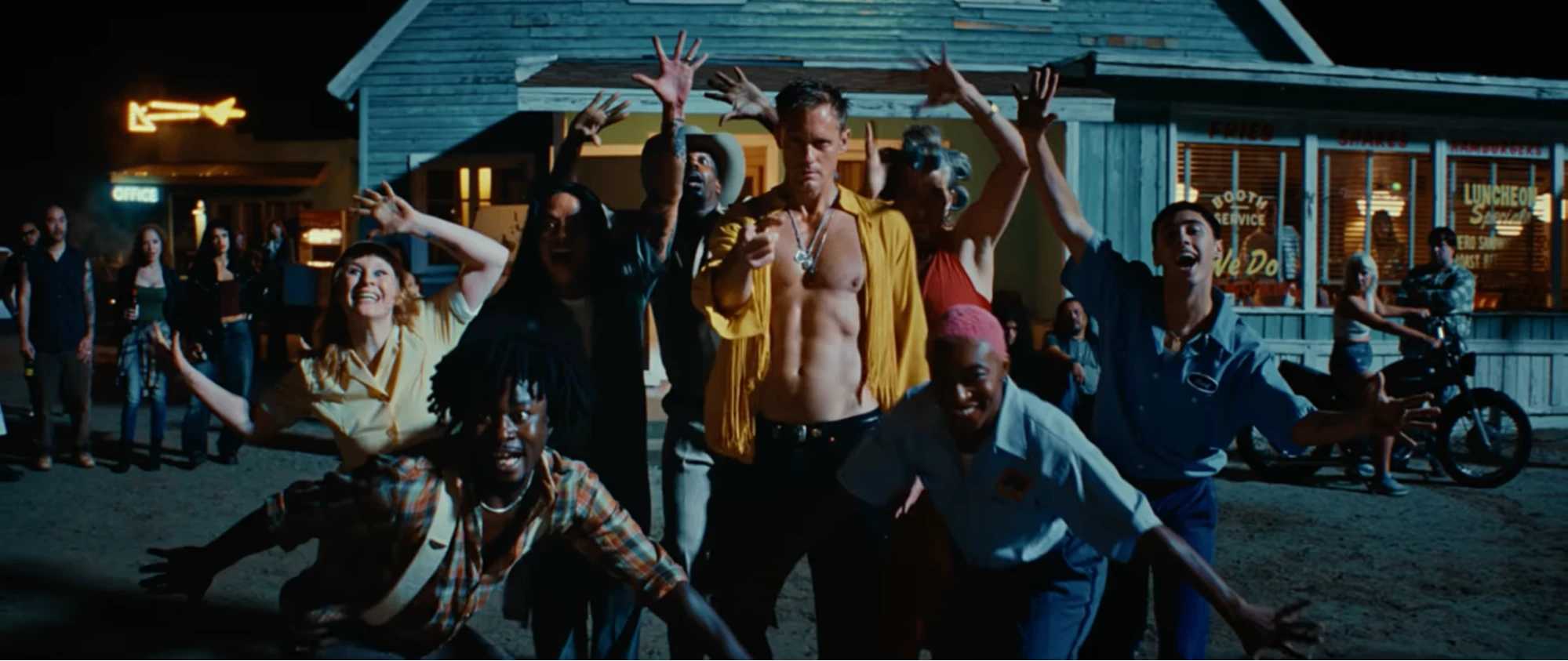 Alexander Skarsgard dances with townspeople in The Rolling Stones' Mr. Charm music video at a roadside diner at night